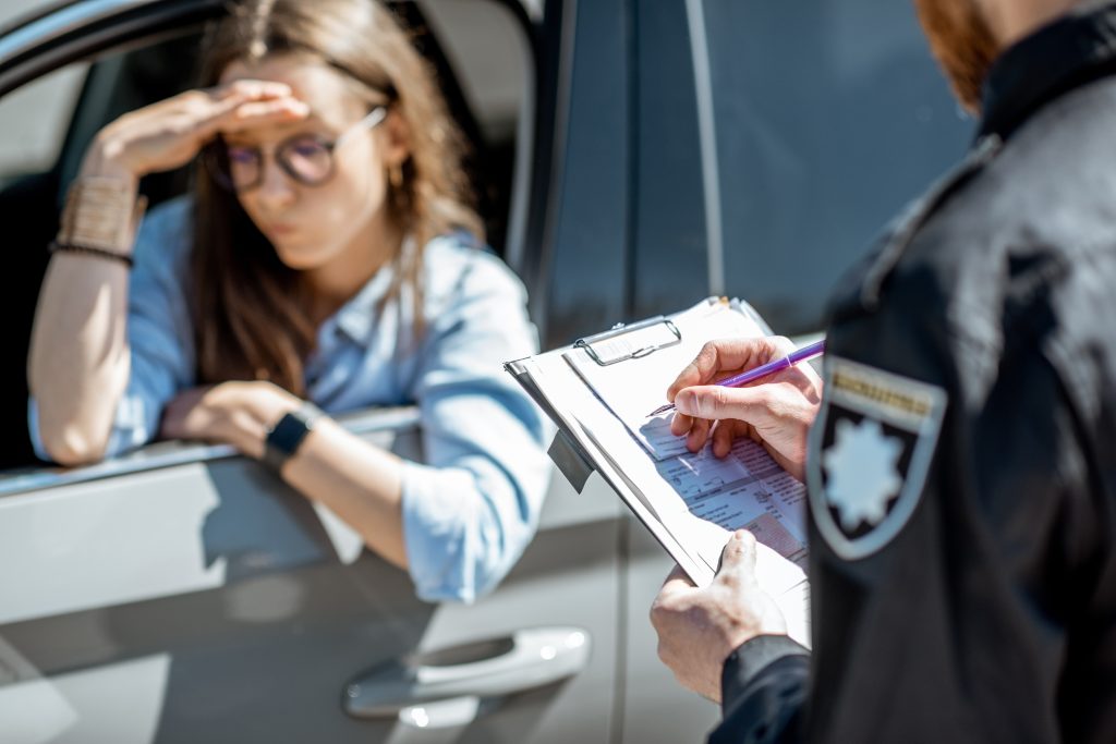 Policeman issuing a fine for a female driver as Police Report